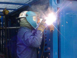 Employee with safety gear welding