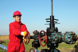 Worker outside opening a pipe valve