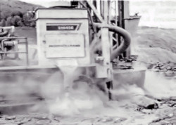 Drilling machine producing dust as earth/rock is drilled