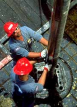 Two well site workers checking the final casing.