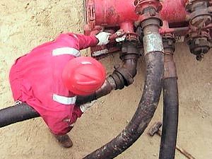 Worker inspecting drilling fluid hoses