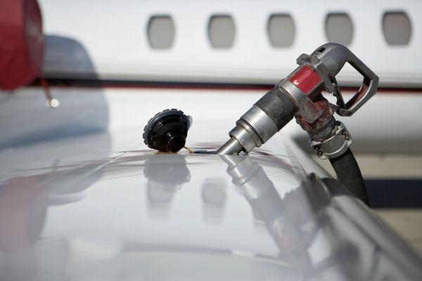 Fuel cap and hose on wing of jet plane