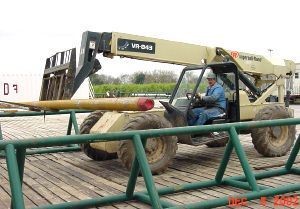 Heavy equipment transporting a pipe